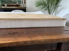 a close up of a mattress on a wooden table in a room with white walls