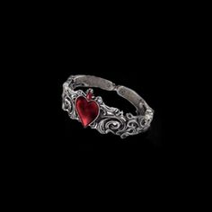 a silver ring with a red heart in the middle and filigrees around it