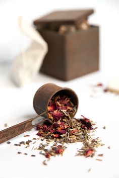 a wooden container filled with dried flowers on top of a white table next to a pair of scissors