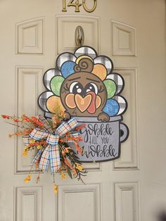 a decorated turkey door hanger on a front door