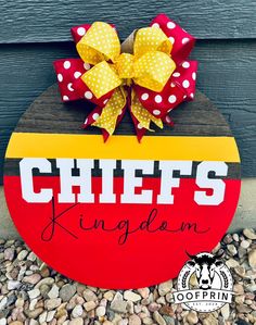 a wooden sign that says chiefs kingdom with polka dot bows on the front and side