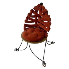 a chair that is made out of some kind of wire and has a cushion on it