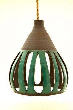 a green and brown hanging light fixture on a white wall with no one in it