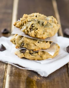 three cookies stacked on top of each other with chocolate chips scattered around them and wrapped in white paper