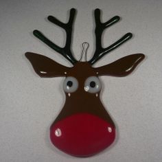 a red nosed reindeer ornament hanging on a wall with eyes and nose painted brown