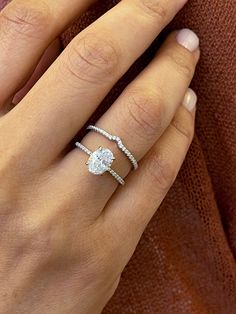 a woman's hand with a diamond ring on her finger and an engagement band