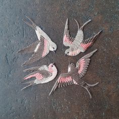 four birds that are sitting in the middle of a circle with wings spread around them