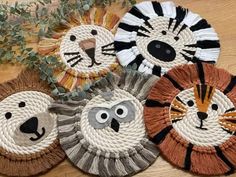 four lion and tiger coasters sitting on top of a wooden table next to a plant