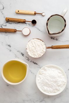 the ingredients for baking are laid out on top of the marble countertop, ready to be mixed together