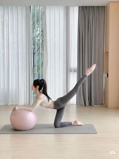 a woman is doing yoga on an exercise ball