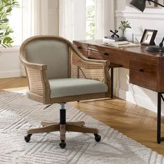 an office chair sitting on top of a rug next to a desk with a lamp