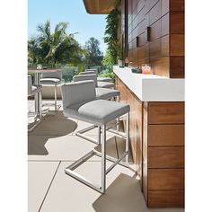 an outdoor bar area with stools and tables