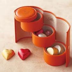 three heart shaped candies in orange containers