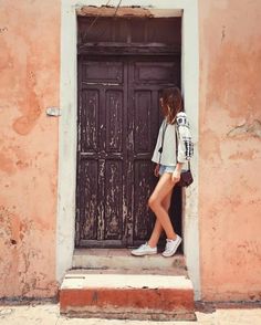 a woman is standing in front of a door