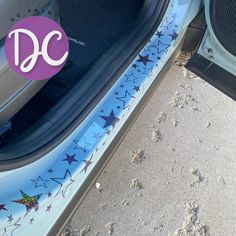 a car door with the word dc painted on it's side and footprints in the sand