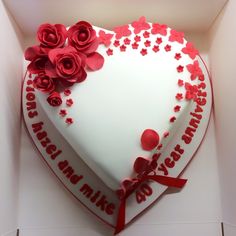 a heart shaped cake with red roses on it