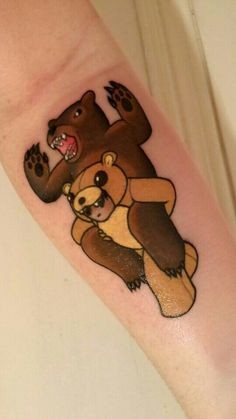 a bear and cub tattoo on the left arm, with one paw in the air