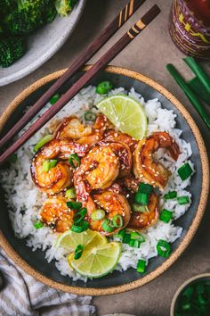 a bowl filled with shrimp and rice next to chopsticks