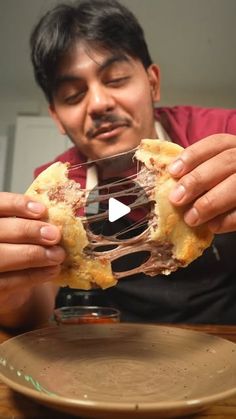 a man holding up a piece of food in front of his face