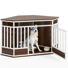 a white dog sitting in a wooden kennel