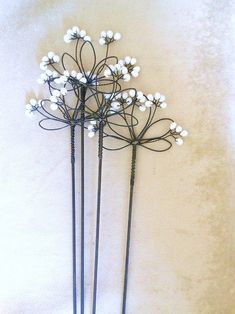 three black and white metal flowers are on the wall next to each other, with one flower in it's center