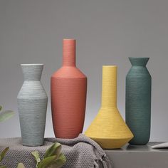 five different colored vases sitting next to each other