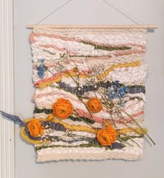 a wall hanging made out of fabric and flowers