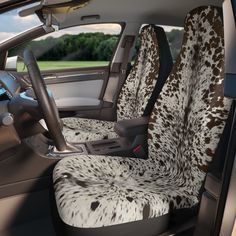 the interior of a car is decorated with spotted cowhides and black leather seats