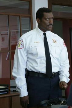 a man in uniform standing next to a desk