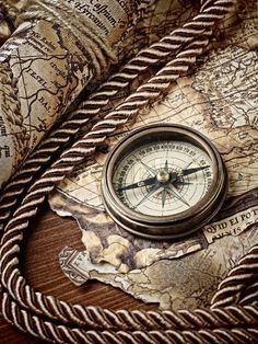 a compass and rope on top of a map