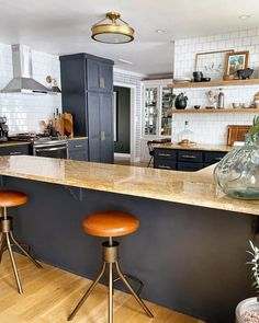 a kitchen with two stools and an island