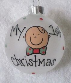 a glass ornament with a baby's face and the words my first christmas on it