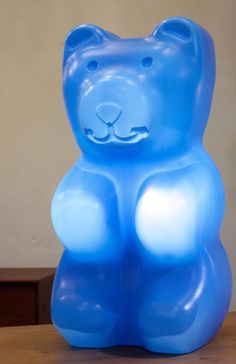 a blue plastic bear sitting on top of a wooden table