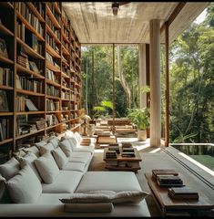 a living room filled with white couches and lots of books on the shelves in front of them