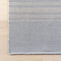 the grey and white striped rug is laying on top of a wooden floor