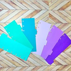 five pieces of colored paper sitting on top of a wooden floor