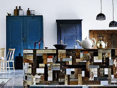 an artisticly designed cabinet in the middle of a room with blue doors and cabinets