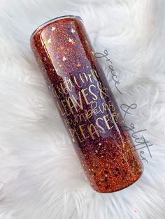 a red and gold glitter tumbler sitting on top of a white fur covered floor