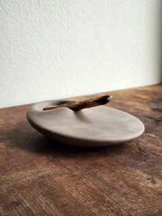 a small white plate sitting on top of a wooden table