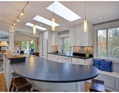 a large kitchen with an island in the middle and lots of windows on both sides