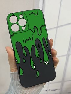 a person holding up a phone case with green liquid dripping down the front and sides