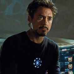 the avengers movie character is looking at something in front of him and his hands on his hips