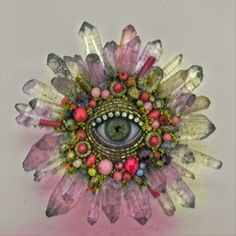 an eye surrounded by crystals and beads