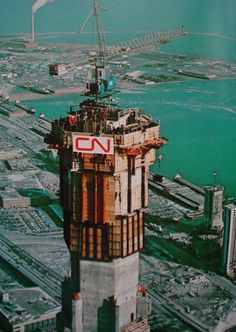 an aerial view of a large tower in the middle of a city with lots of water