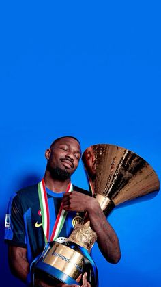 a man is holding a trophy and posing for the camera with it's head in his hand