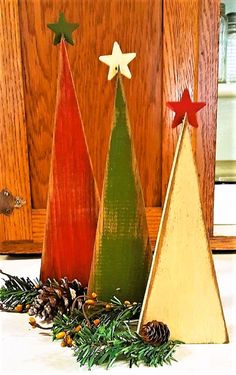 three wooden christmas trees sitting next to each other