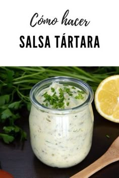 a jar filled with salsa and garnished with cilantro next to a wooden spoon