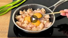 someone is cooking food in a pan on the stove top with chopsticks next to it