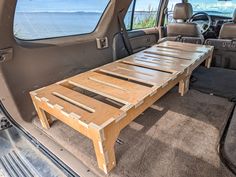 a table in the back of a car with its doors open and seats folded down