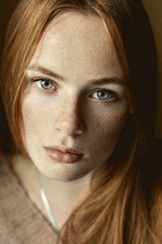 a woman with long red hair and blue eyes